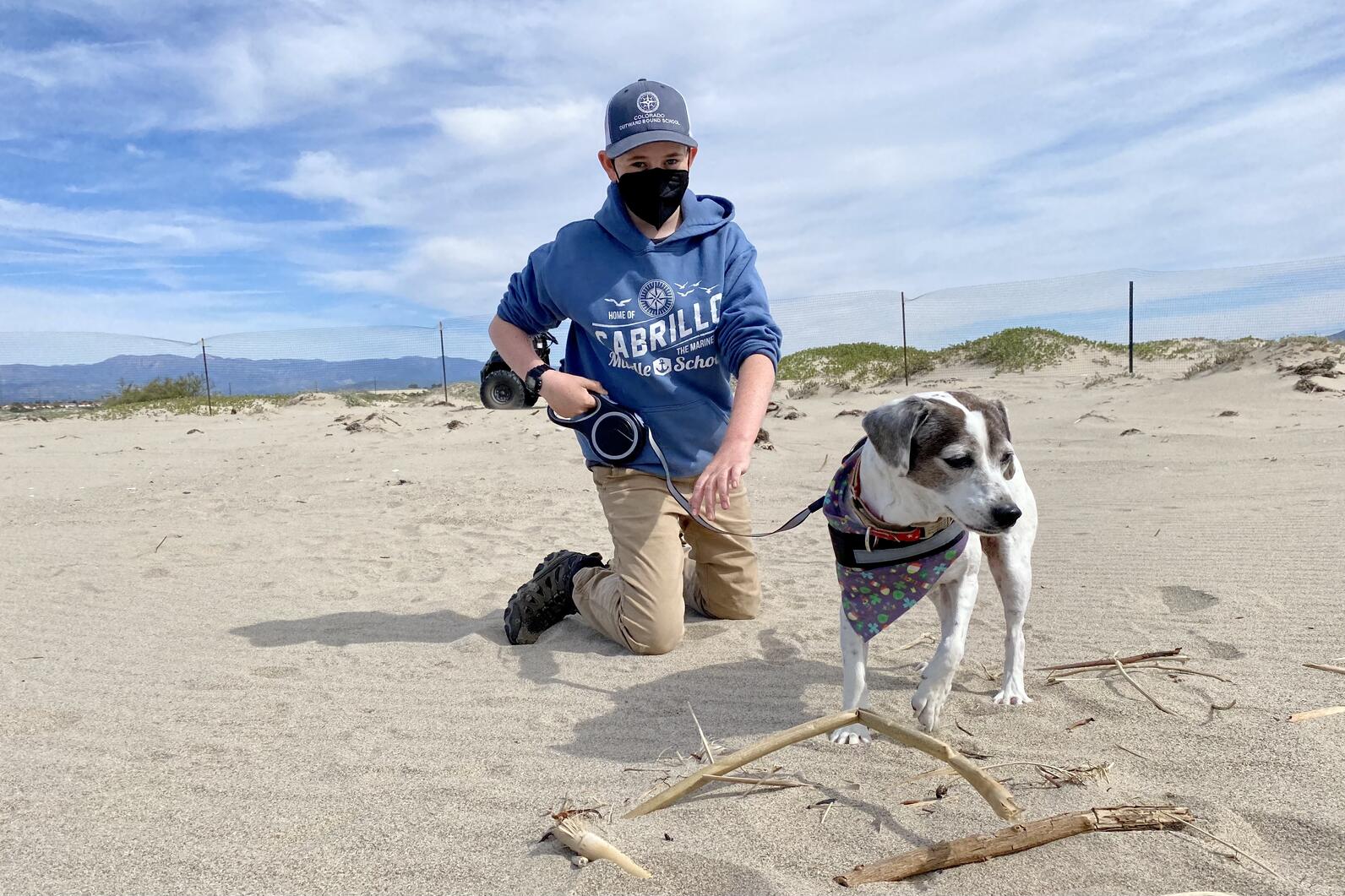 Max Breshears retrieves a leashed dog that momentarily walked on the beach unattended, away from its owner.