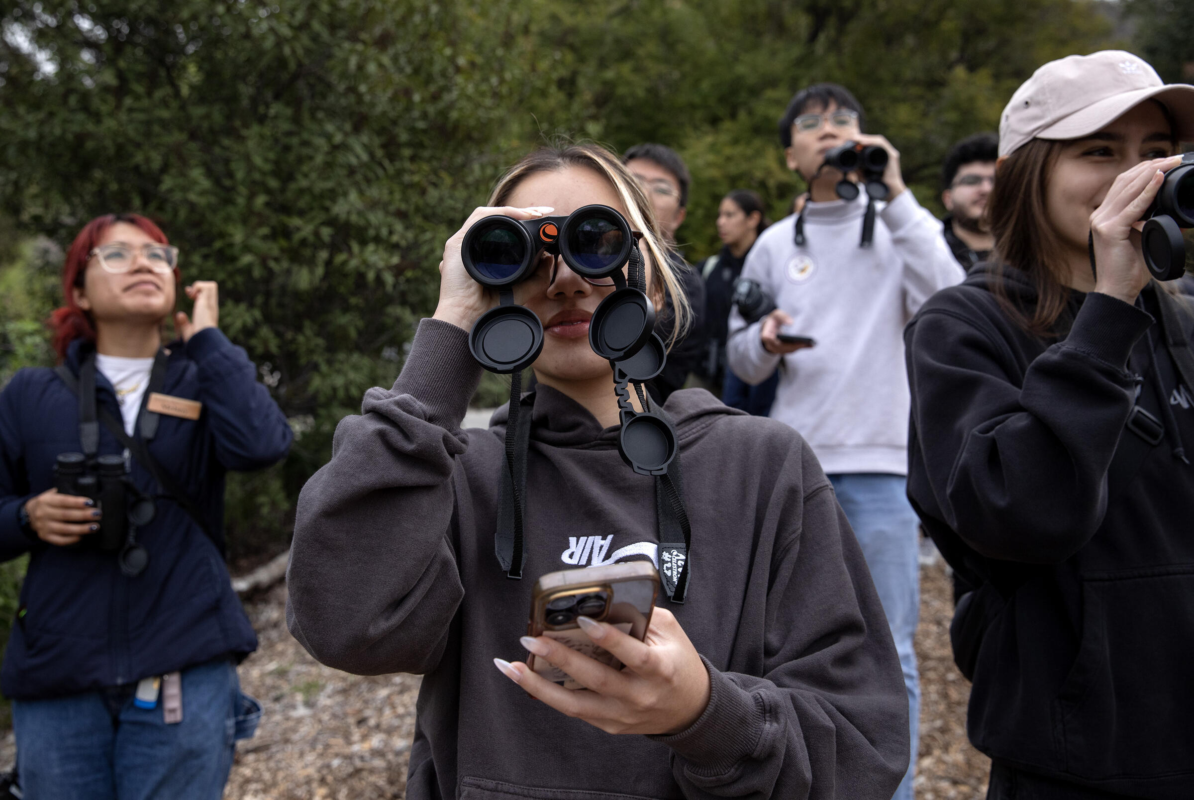 Photo of several young folks birding with binoculars